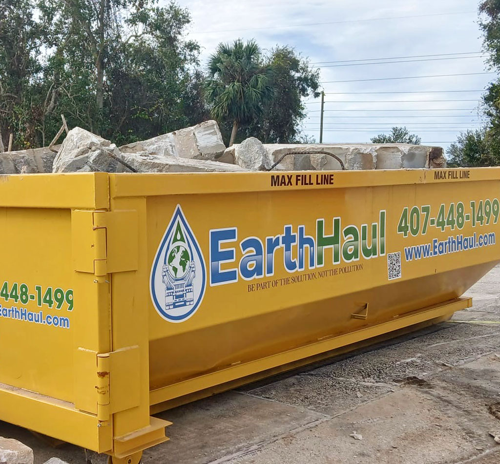 Concrete disposal roll-off dumpster at a job site in Satellite Beach, FL.
